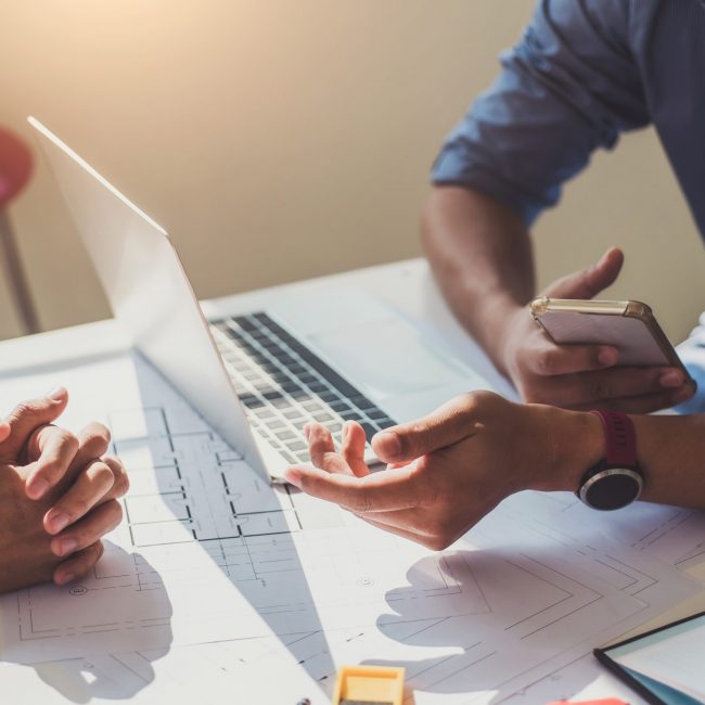 Architects or engineer construction discussing about interior design project with blueprints in architects workplace.